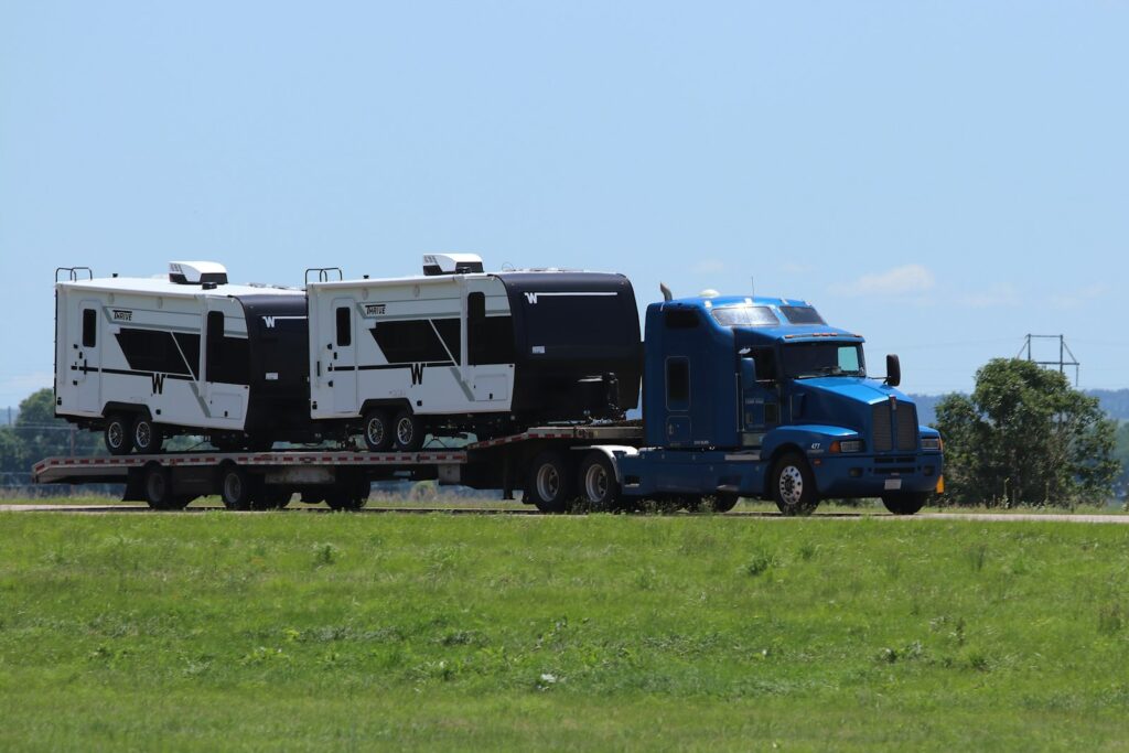 Blue semi-truck with flatbed trailer - Apex Capital factoring review